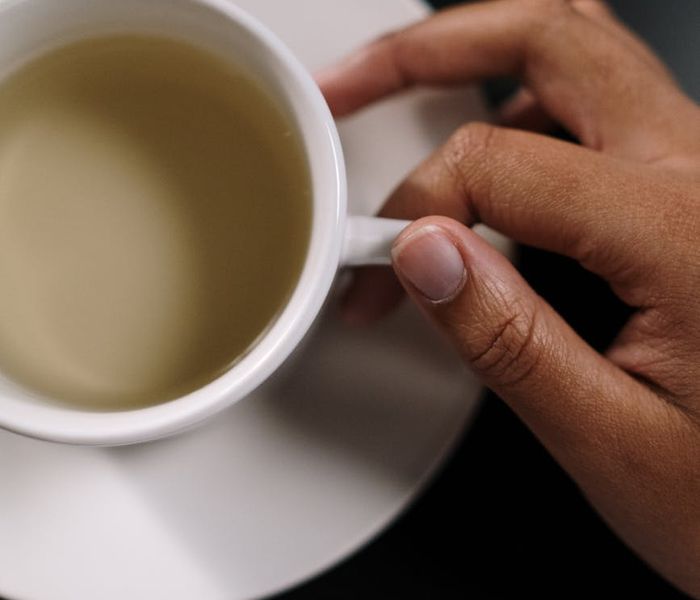 Person hands holding a cup of herbal tea for wellness